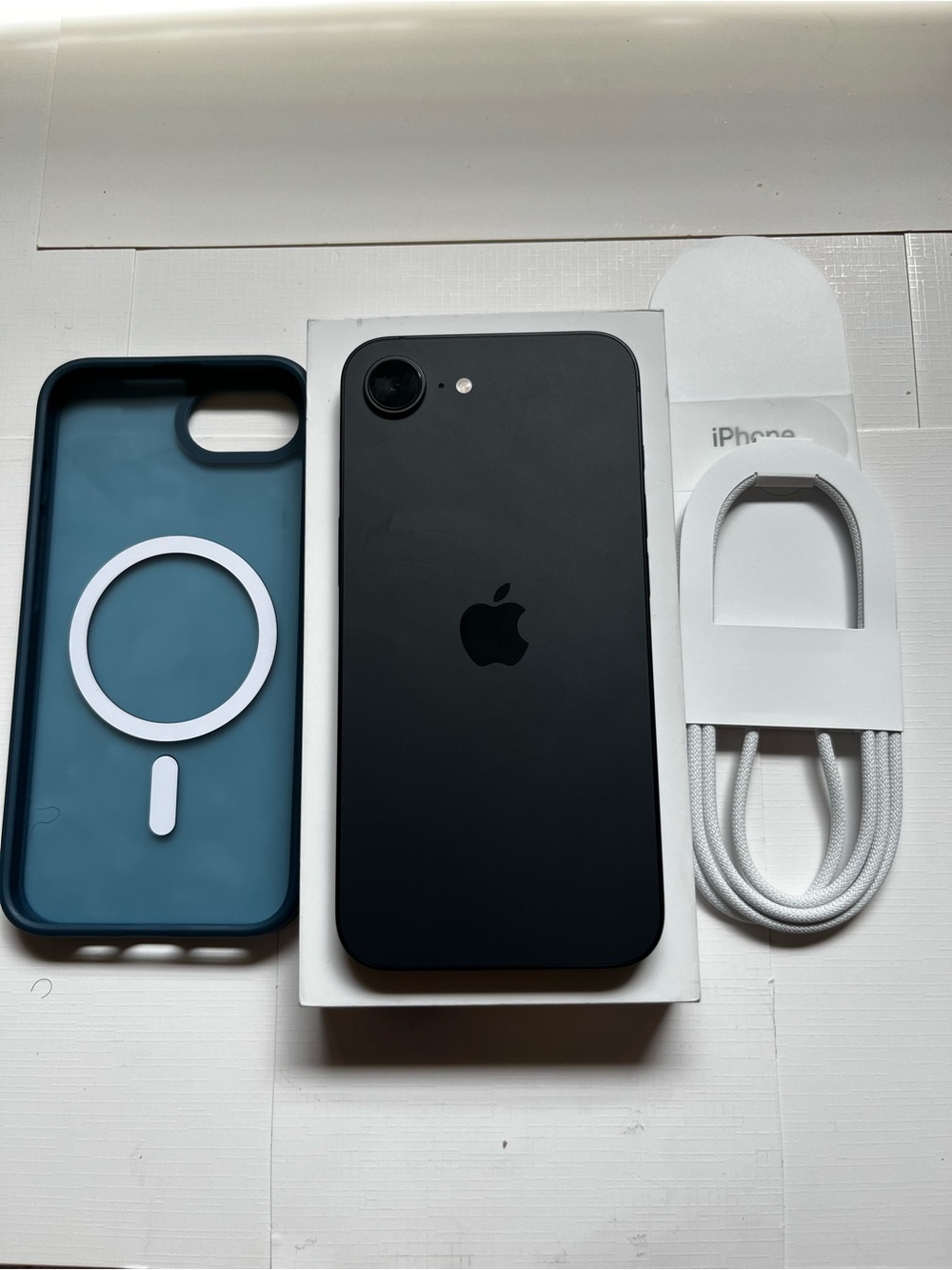 Apple iPhone16e Black with Teal MagSafe-Style Case and White Braided USB-C Cable